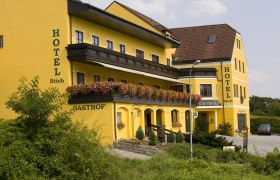 Yellow hotel building with flowers on the balcony.