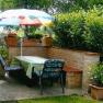 Garden with table, chairs and parasol.