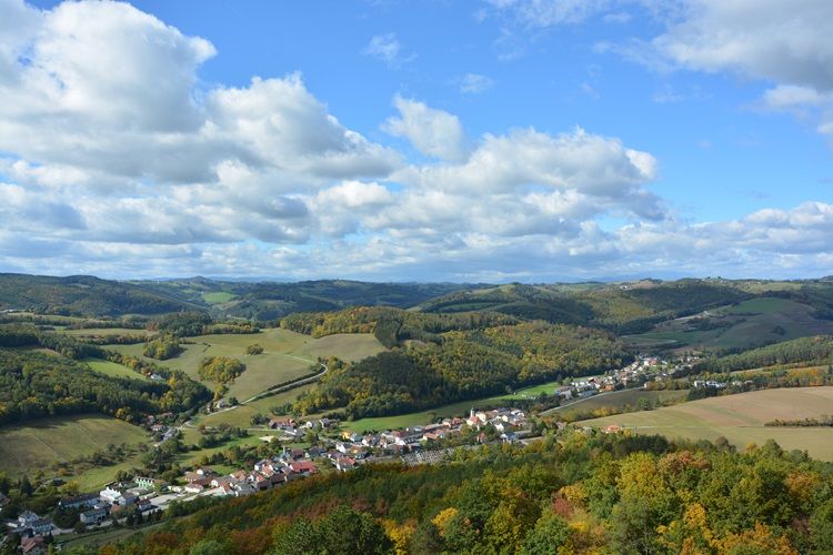 Landscape with hills, forests and a village in the fall.