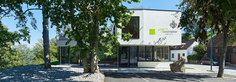 Modern wine pavilion in Hollenburg surrounded by trees.