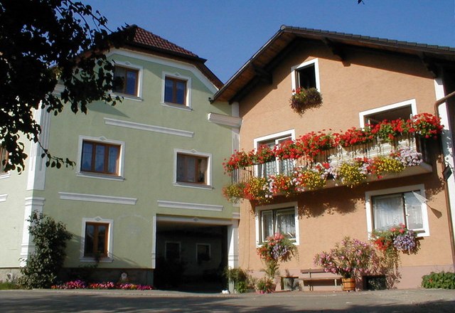 Willi's farm, © Willi´s Bauernhof Two farm buildings with colorful flowers on the balconies.