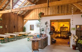 Interior view of a rustic room with wooden beams, beer tables and a creative room.