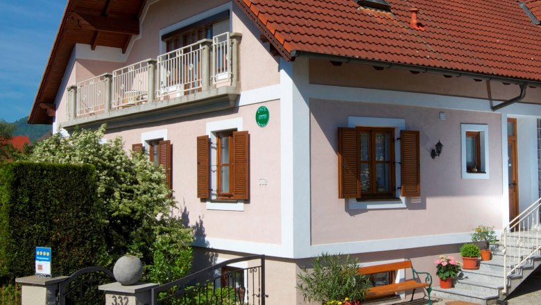 Guesthouse Punz, © Familie Punz A two-storey house with a red tiled roof, balcony and garden.