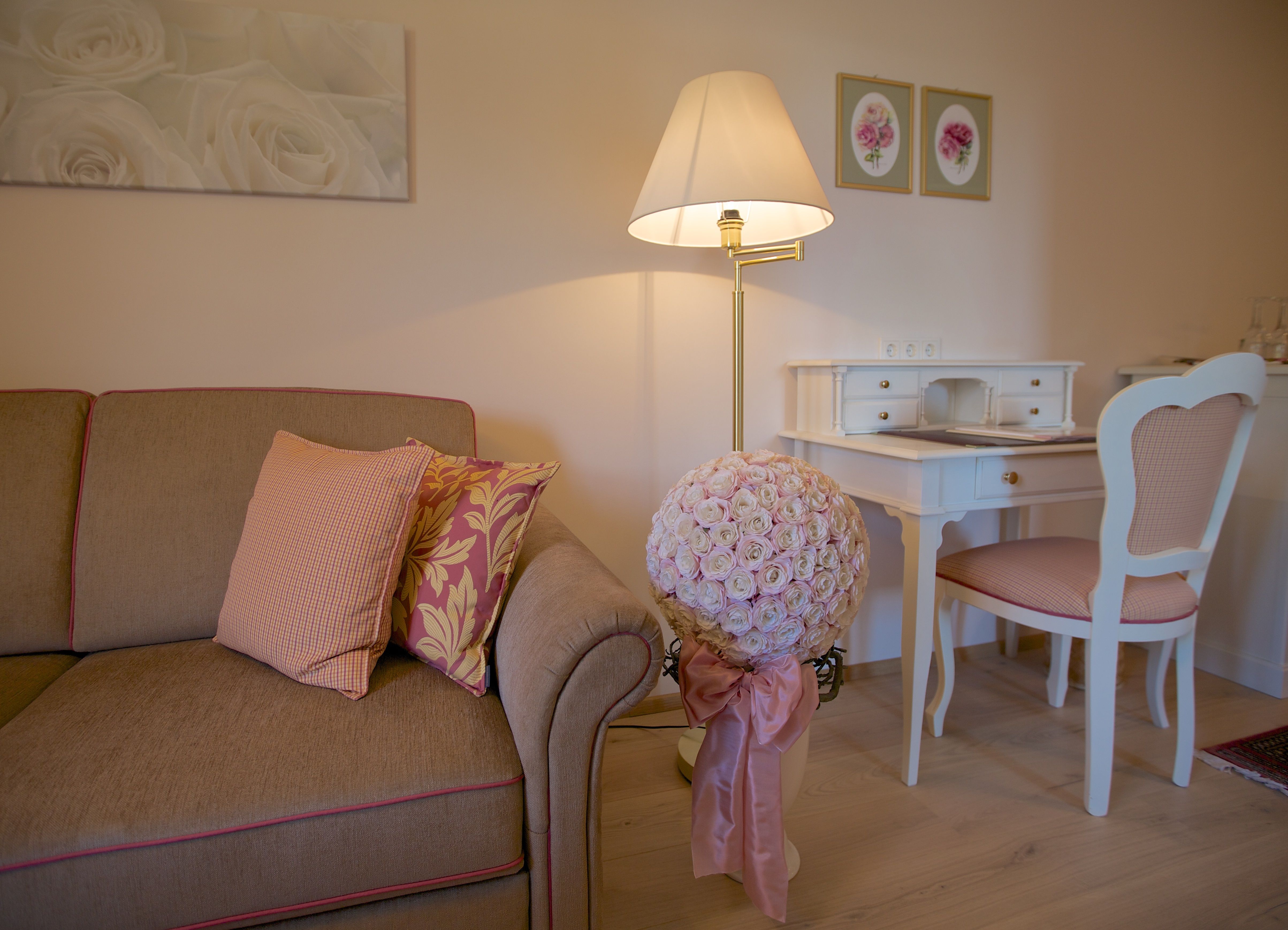 Cozy living room with sofa, desk and flower arrangement.