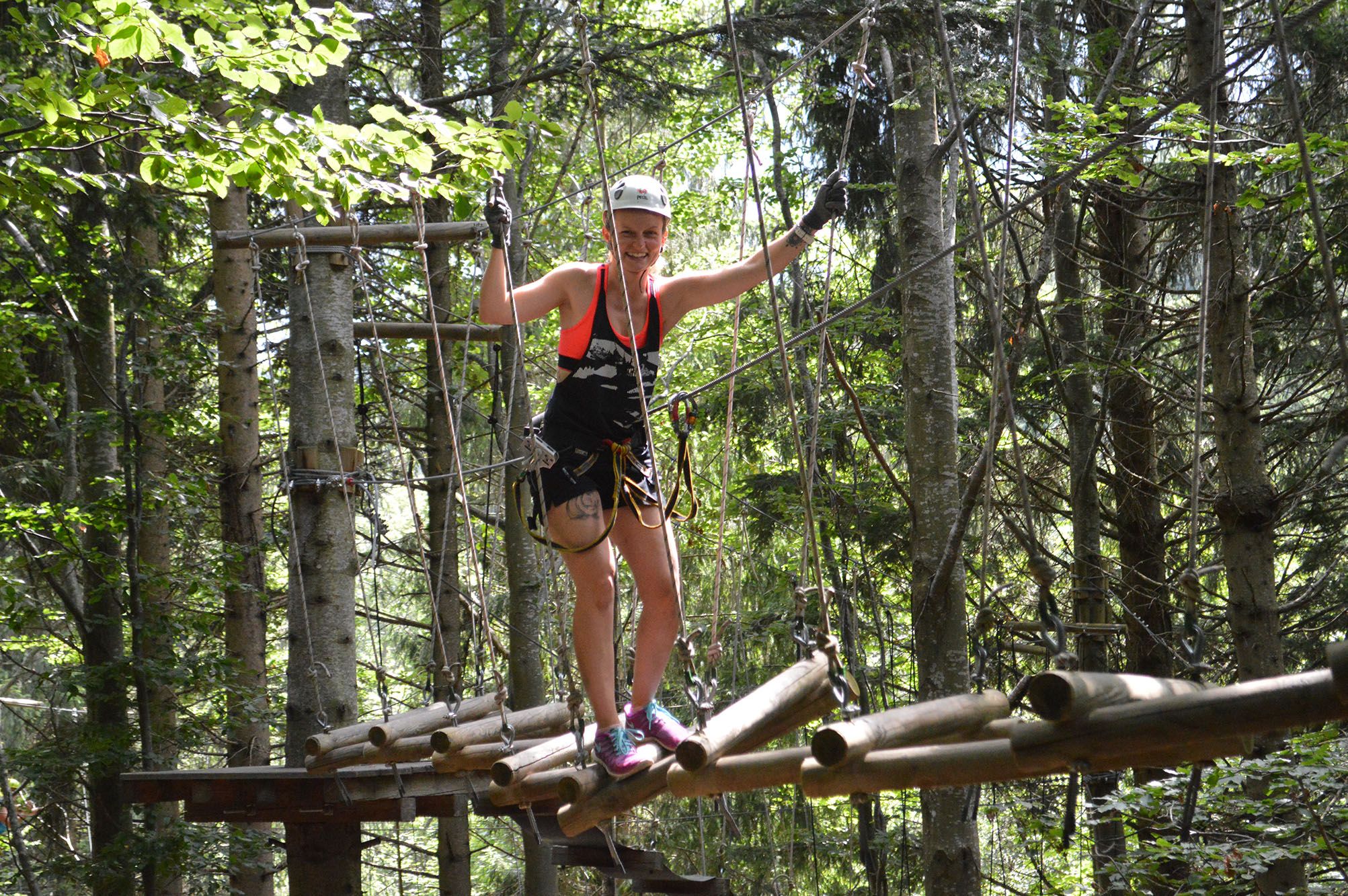 Person on a high ropes course in the forest.