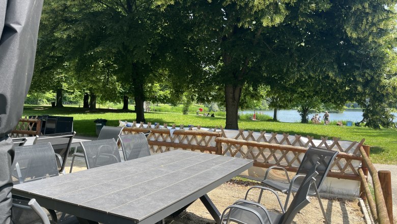 Gartentisch mit Gartenstühlen, im Hintergrund das Tullner-Aubad.