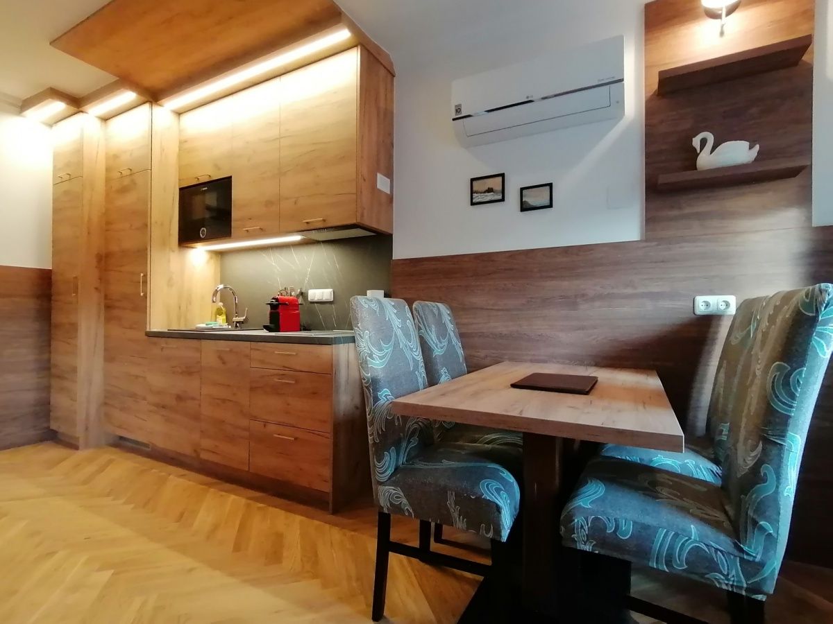 Modern kitchen with wooden furniture and dining table in an apartment.