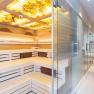 Interior view of a modern spa area with sauna and glass door.