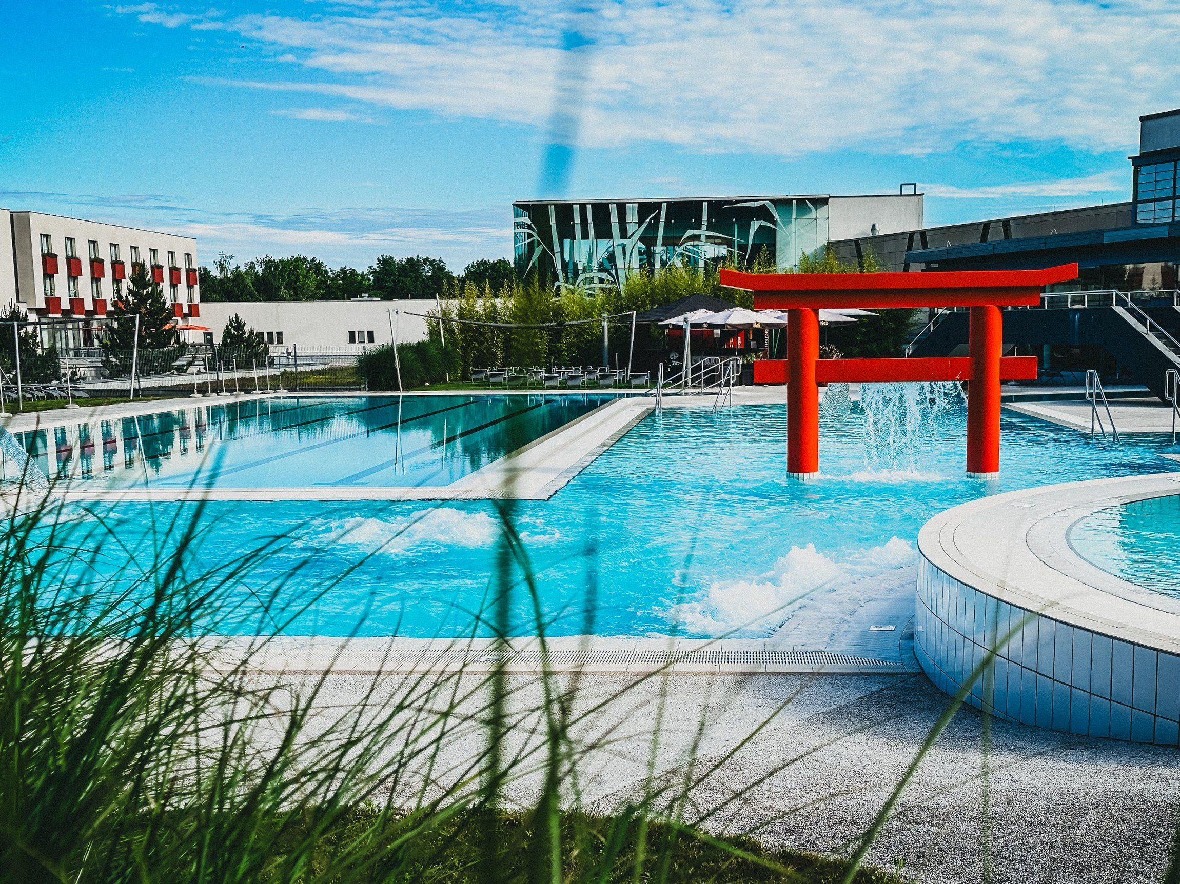 Exterior view of the Linsberg Asia Therme with pool and red torii.