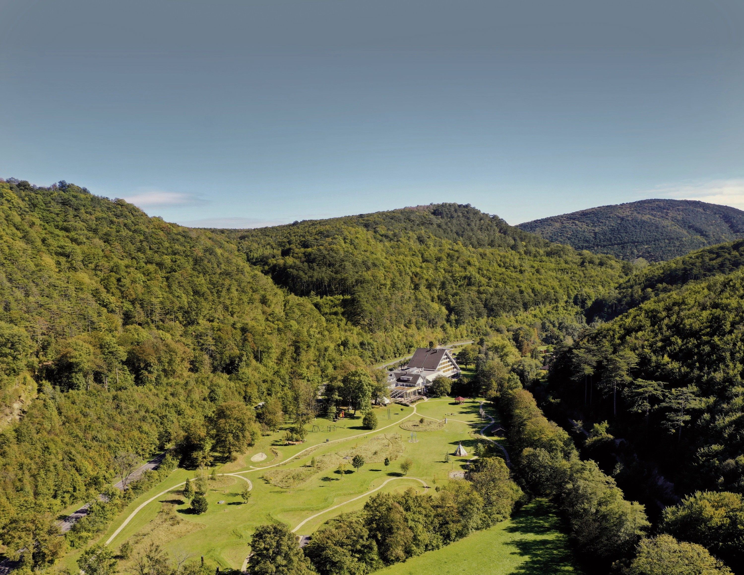 Aerial view of the Krainerhütte amidst wooded hills.