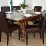 Dining area with wooden table and six brown chairs, set for six people.
