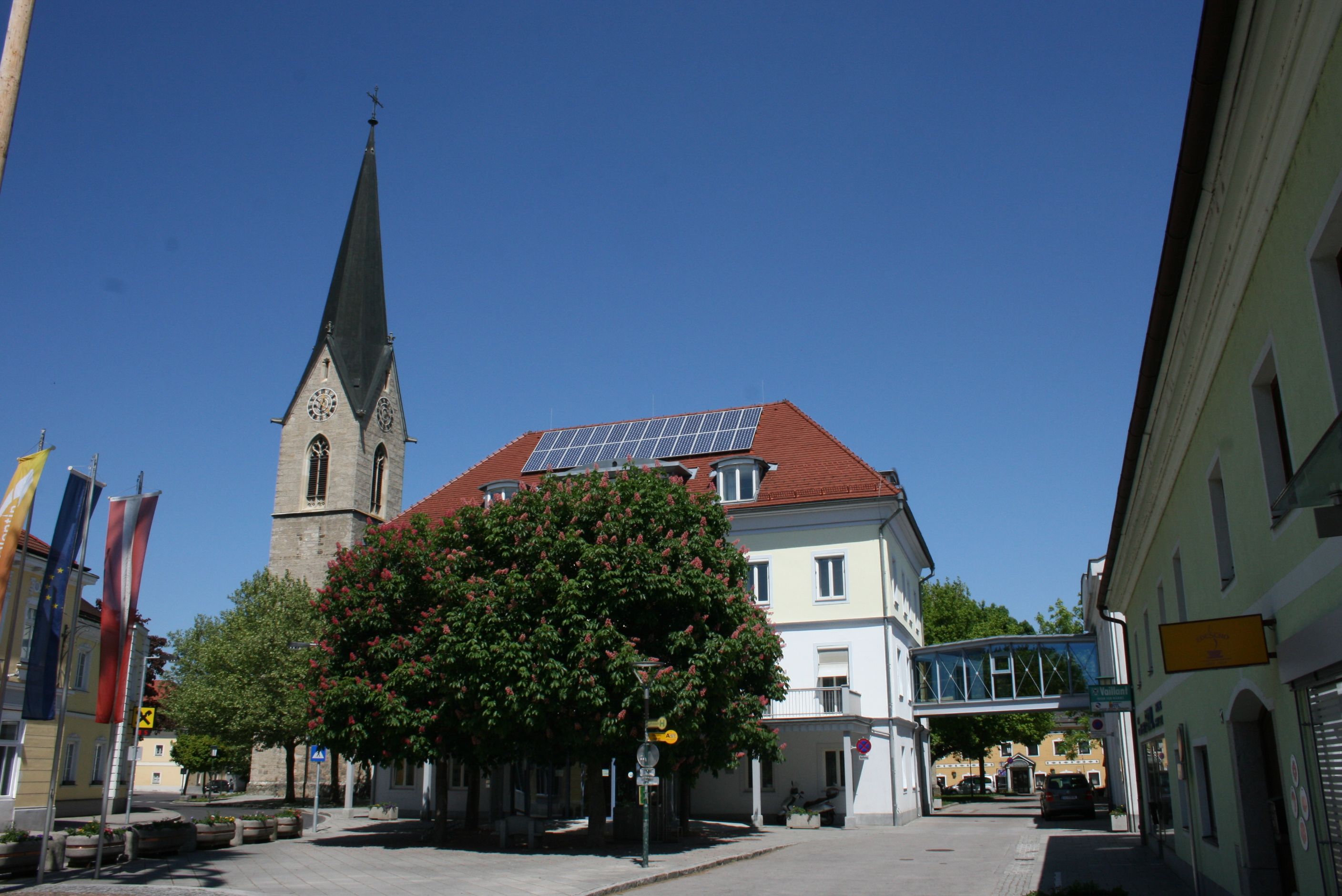 Church tower and building in St. Valentin with blue sky.