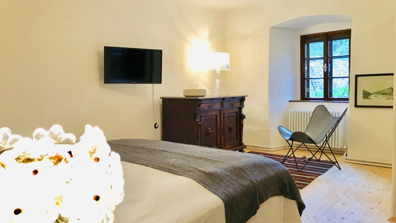 Bedroom, © Fam. Georgoulopous Cozy bedroom with bed, antique chest of drawers, armchair and wall-mounted TV.