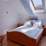 Bright bedroom with wooden bed, skylight and blue decoration.