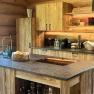 Rustic wooden kitchen with modern equipment and view to the outside.