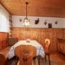 Cozy cellar room with wooden furniture, corner bench, table, radio and hunting trophies on the wall.