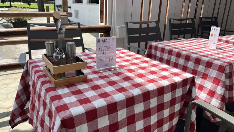 Table setting with red tablecloth and food recommendation.