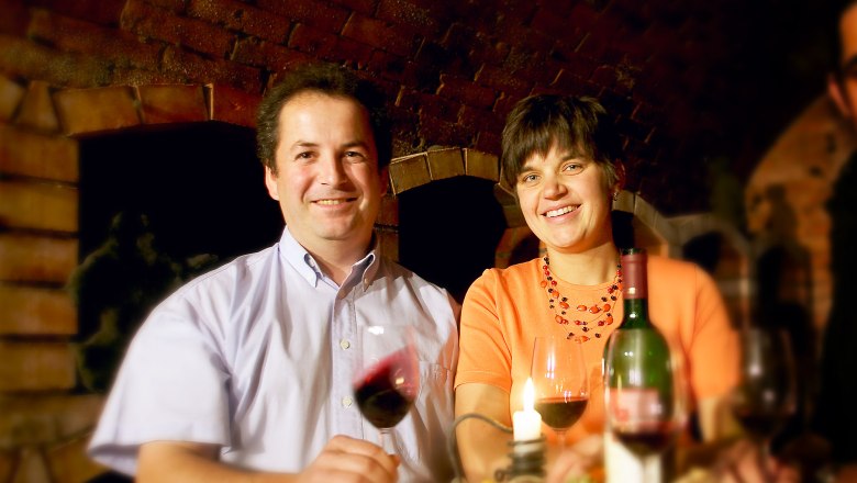 Krottendorfer family, © Lehmann A man and a woman are sitting at a table with wine and a candle.