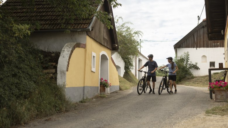 Two cyclists in the &Ouml;hlbergkellergasse in Pillersdorf.