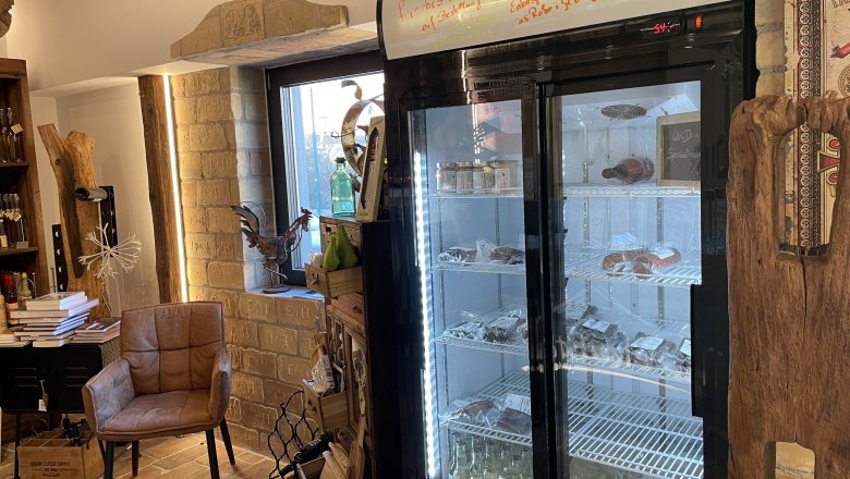 Interior view of a store with refrigerator, chair and decorations.