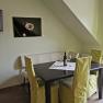 Dining area in a vacation apartment with table, chairs and bottle of wine.
