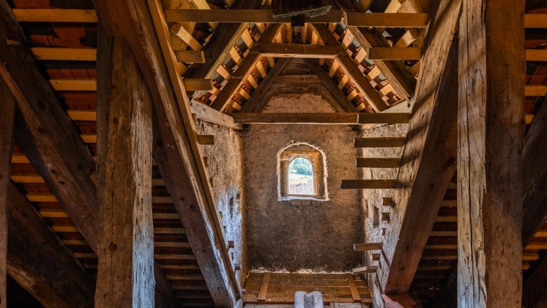 Interior view of the upper floor of the Edlitz fortified church with wooden beams and small window.