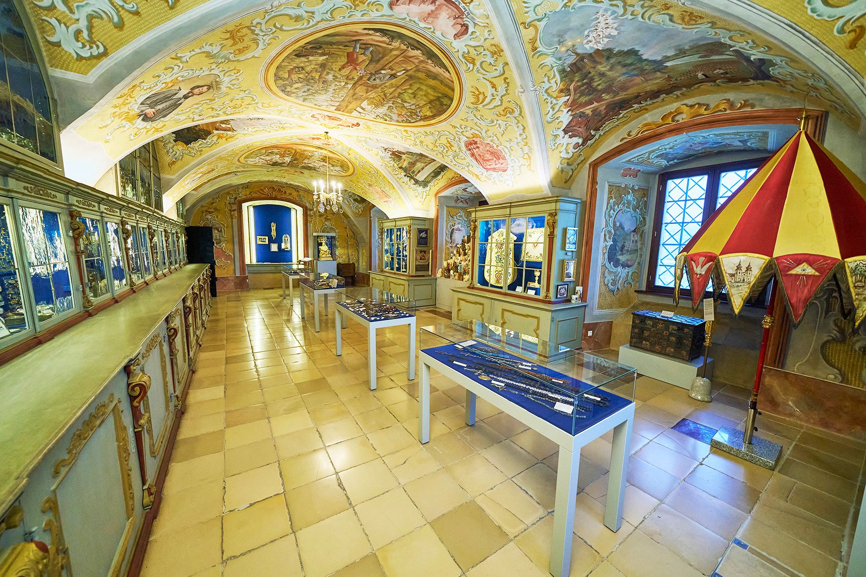 Interior view of the treasury of Maria Taferl Basilica with decorated ceilings and display cases.