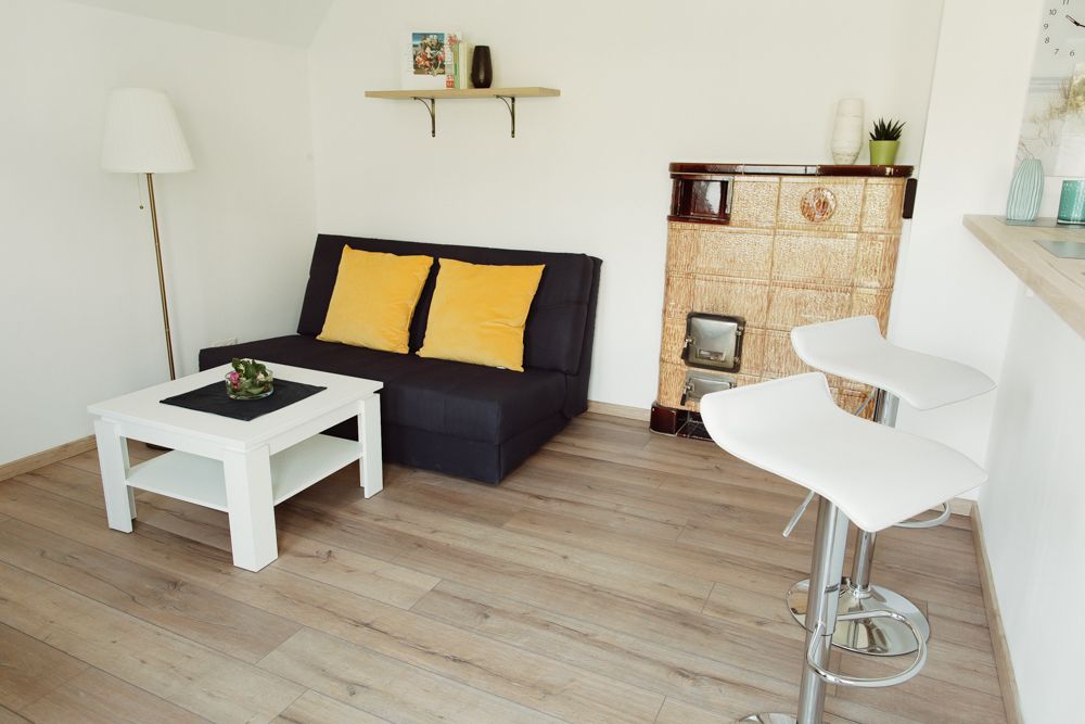 Modern living room with sofa, coffee table, bar stools and fireplace.
