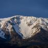 Snow-covered mountain under a blue sky.