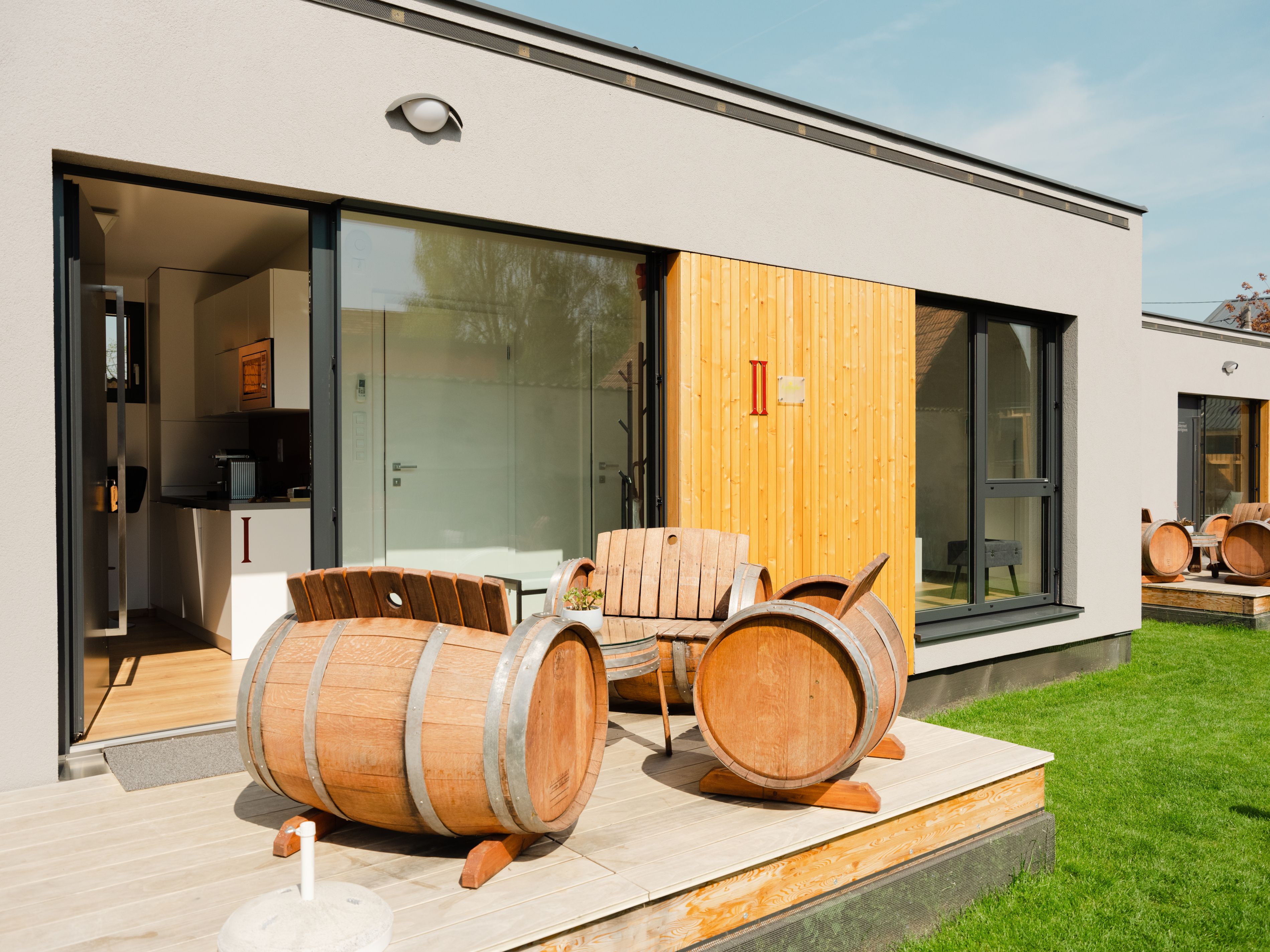 Modern terrace with wine barrel furniture in front of an apartment.