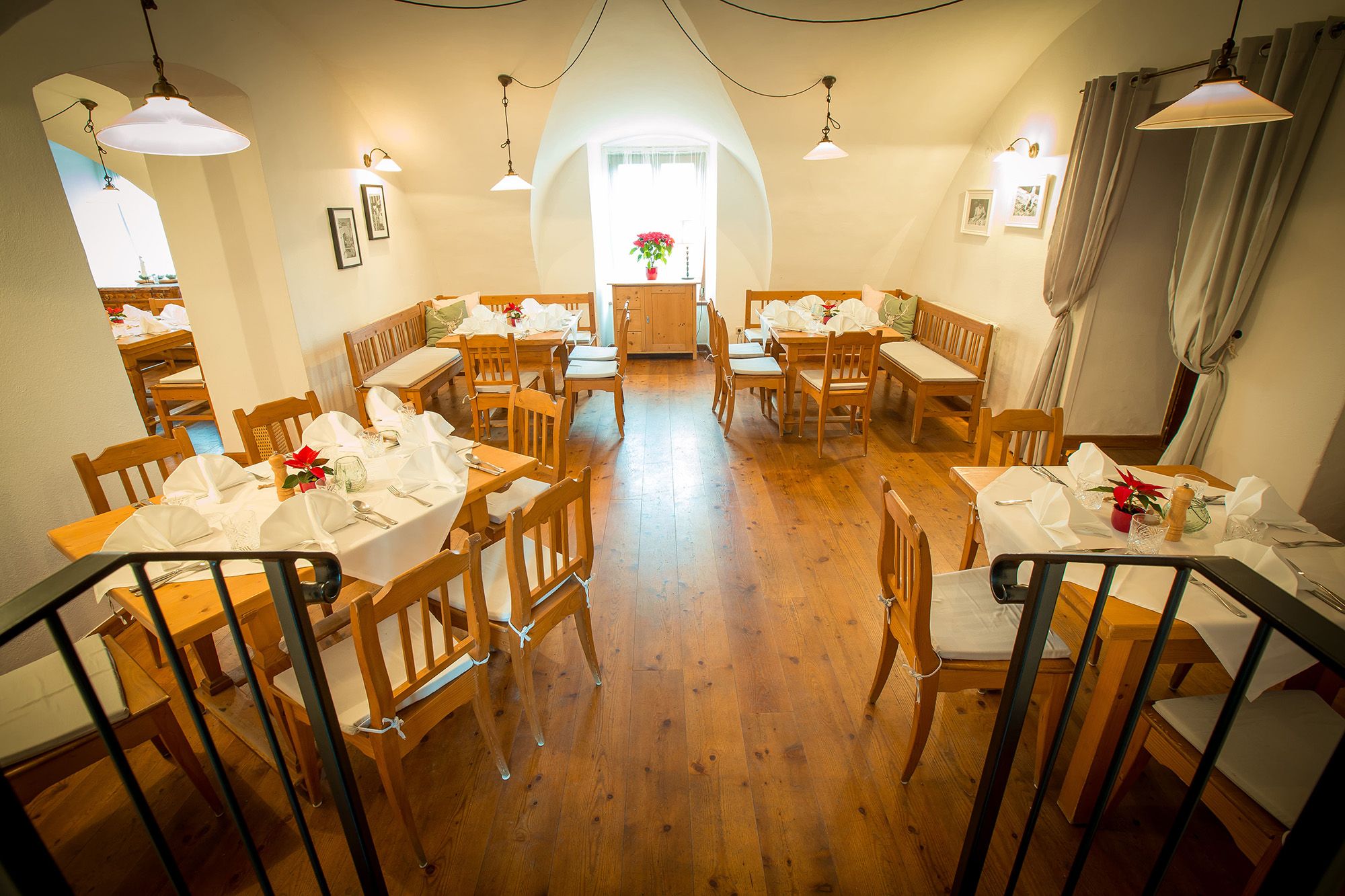 Cozy restaurant with wooden furniture and white-clothed tables.