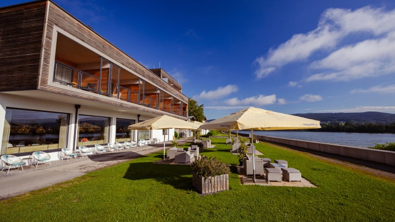 Modern lodge with terrace and sunshades on the riverbank.