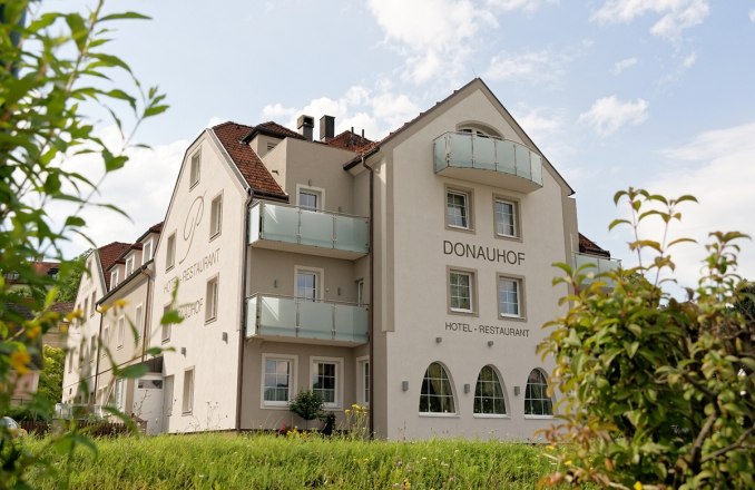 Exterior view of the Hotel Restaurant Donauhof with balconies and garden.