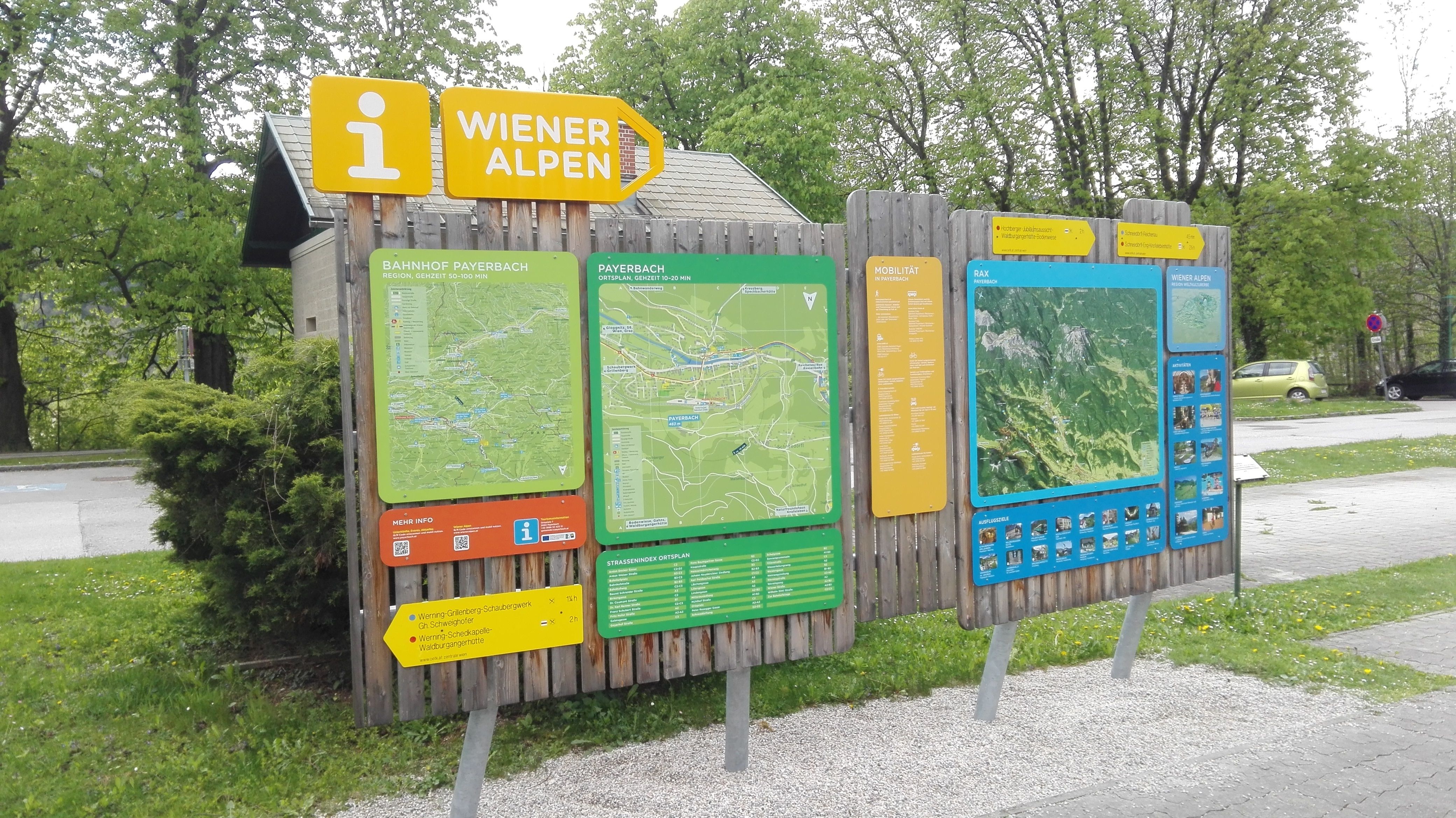 Information boards at the Payerbach hiking starting point with maps and signposts to the Vienna Alps.