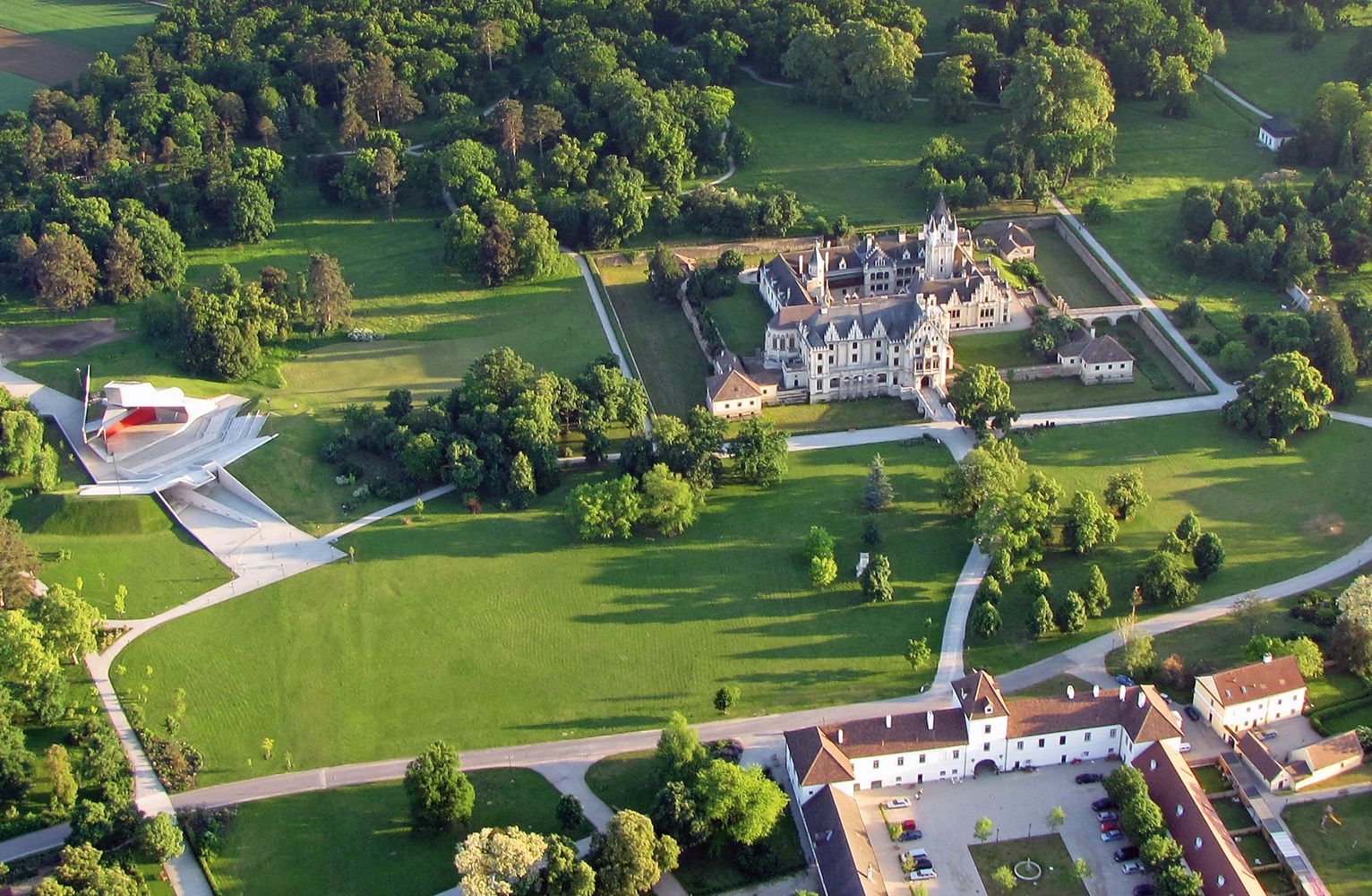 Aerial view of Grafenegg Castle with surrounding park and modern stage.