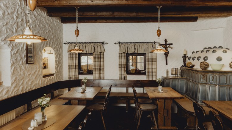 Cozy parlor with wooden furniture, tiled stove and rustic decoration.