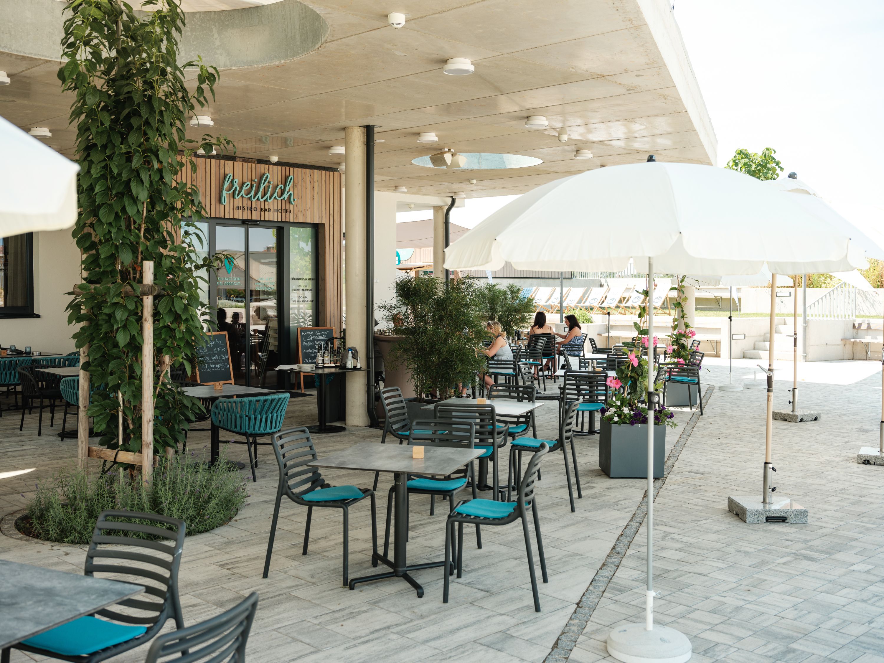 Outdoor area of a café with tables, chairs and parasols.