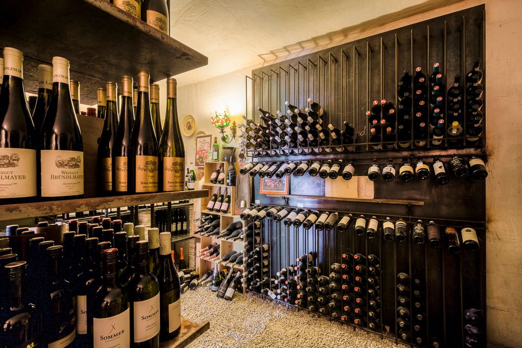 A wine cellar with shelves full of wine bottles neatly stacked.