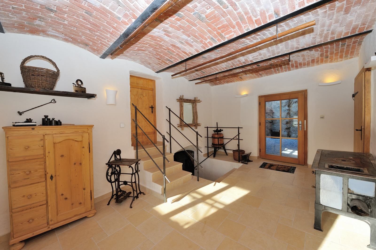 Interior with vaulted ceiling, wooden furniture and antique objects.