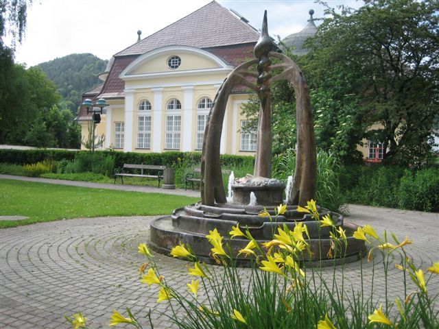 Fountain in front of a historic building with yellow flowers in the foreground.