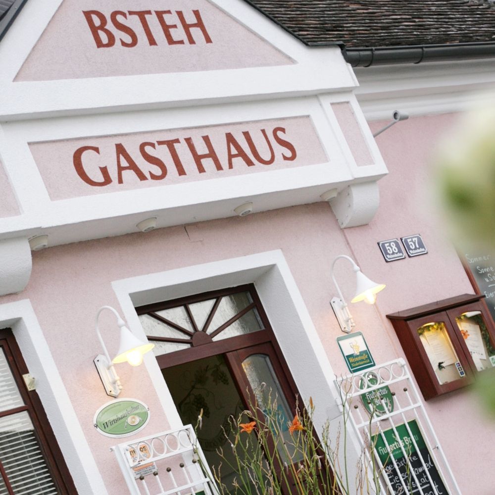 Entrance of an inn with pink facade and signage.