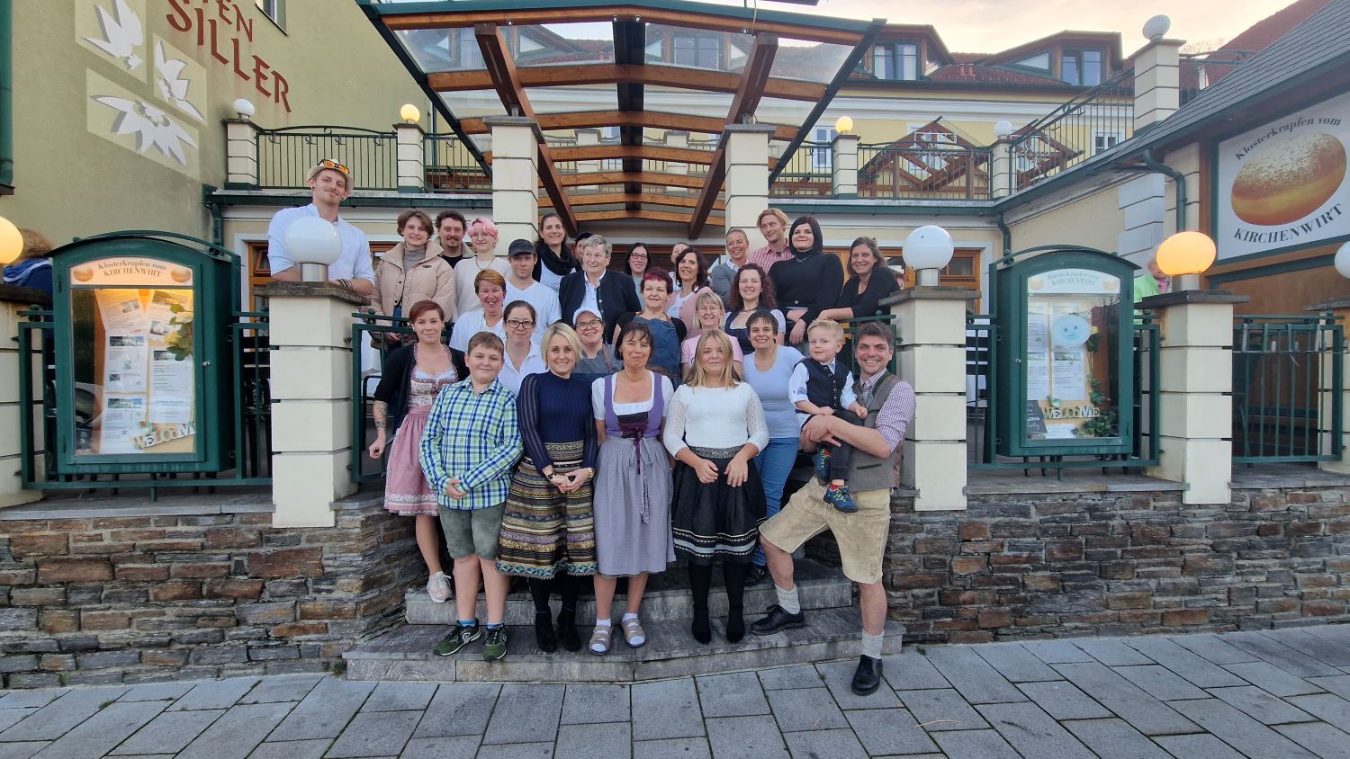A group of people stand in front of a building labeled 'Kirchenwirt'.