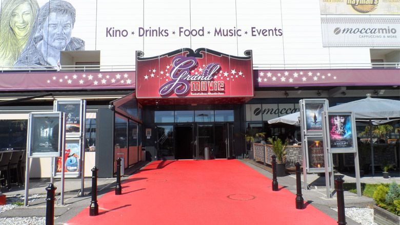 Entrance to the Grand Movie Cinema in Neunkirchen with red carpet.
