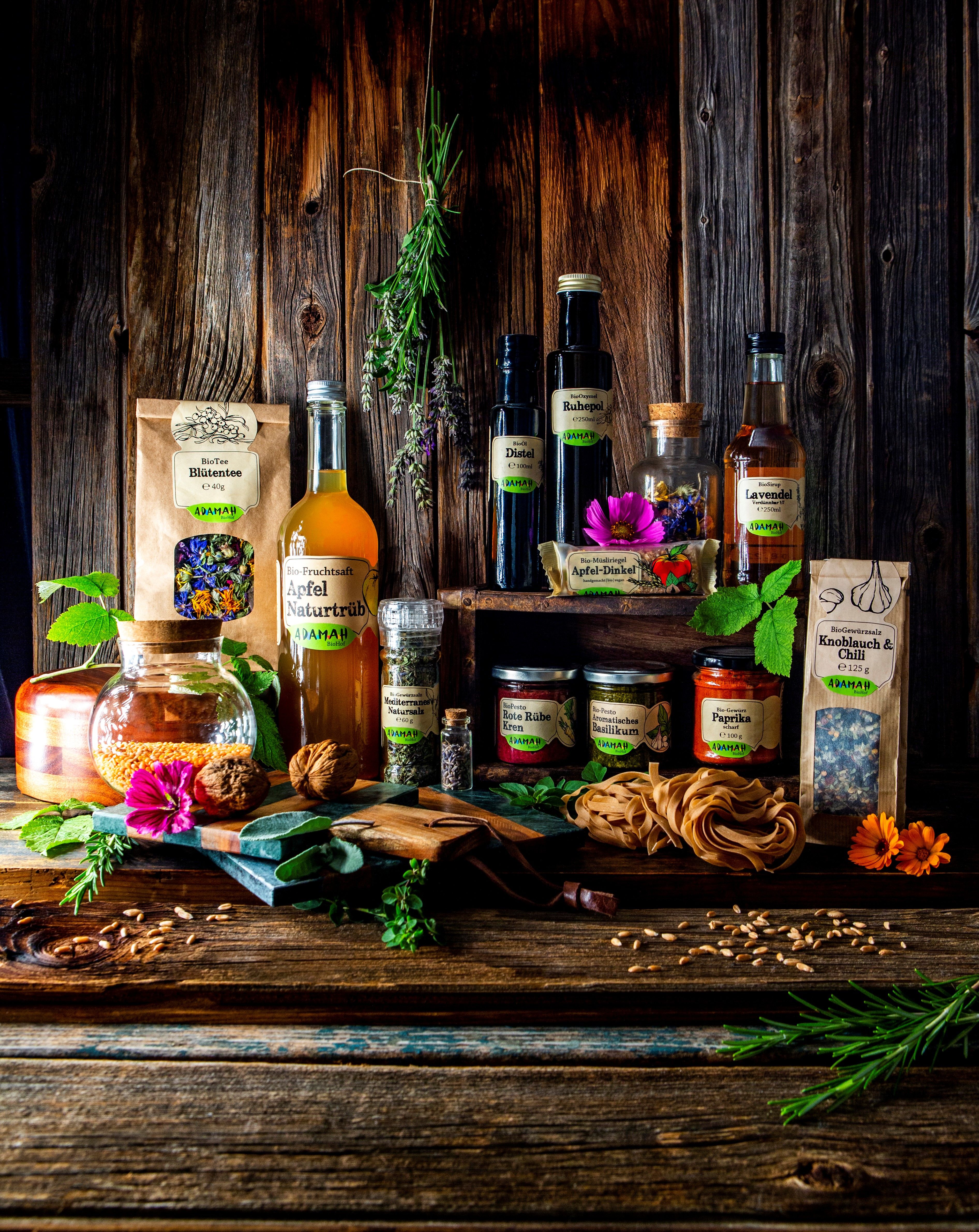 Various ADAMAH organic products arranged on a rustic wooden table.