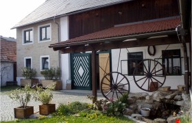 Traditional building with wooden roof and decorative wagon wheels in the courtyard.