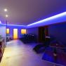 A modern wellness area with loungers, tables and blue lighting.
