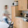 Modern kitchen with wooden furniture and one person on the move.
