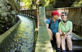 A couple takes a break on the steps of the footbridge, right next to the Trift Canal.