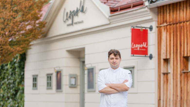 Cook in white uniform in front of the Leopold restaurant.
