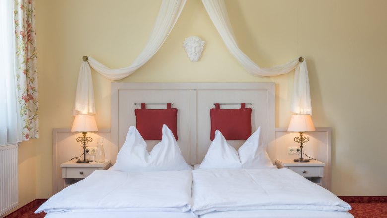 Rooms Hotel Wachau, © Hotel Wachau Room view with four-poster bed and red upholstery